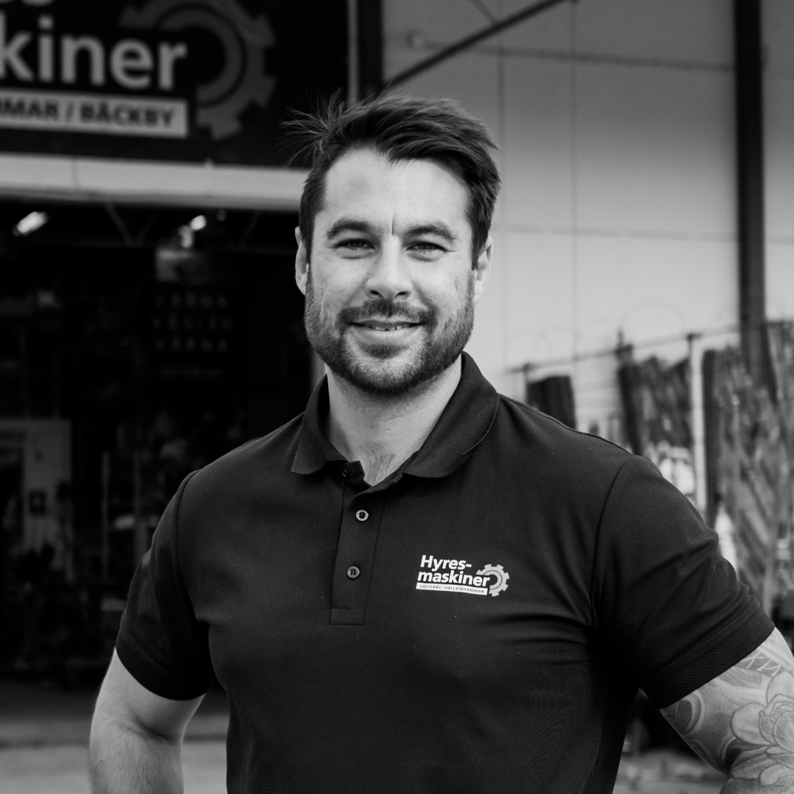 Picture of man in front of equipment hire shop black and white