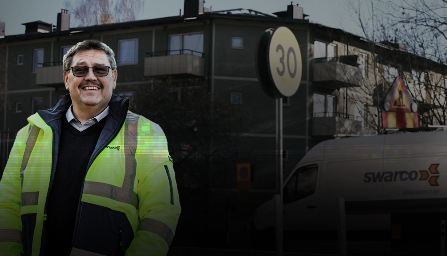 Man in high visibility jacket in front of company car and street signs