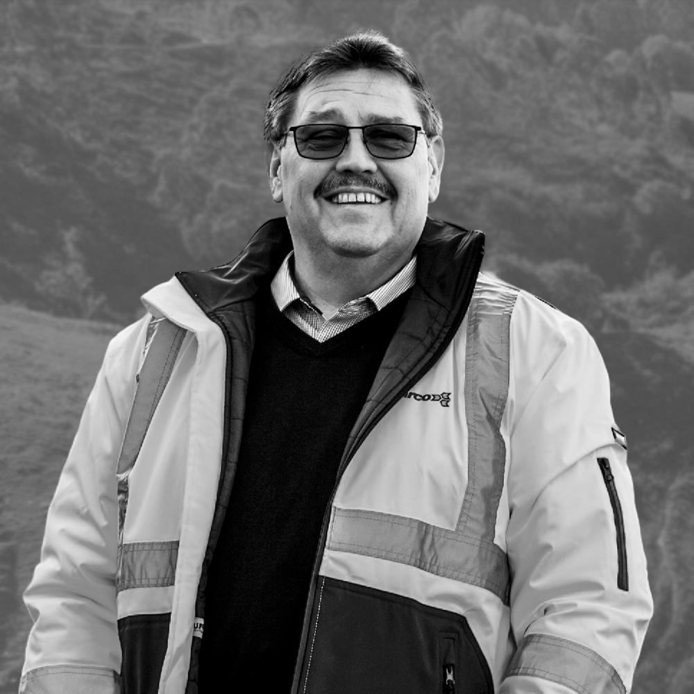 Man with sunglasses and builder jacket smiling