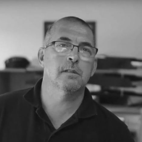 Man talking to camera in office environment black and white