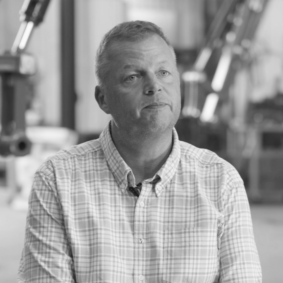 Photo of Mats Ericsson in front of machines black and white