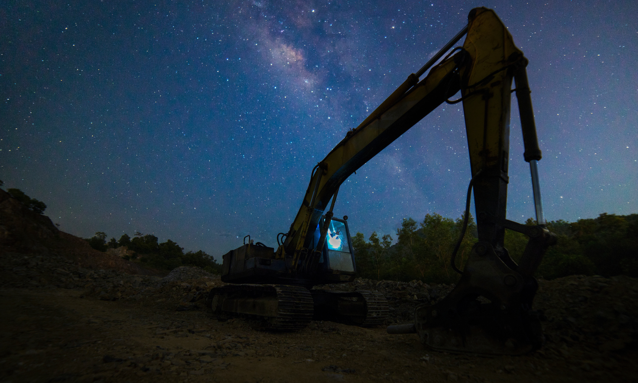 digger excavator in the dark with stars behind
