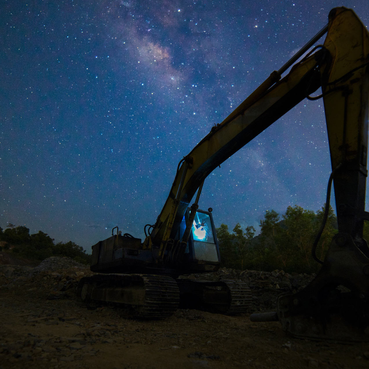 digger excavator in the dark with stars behind