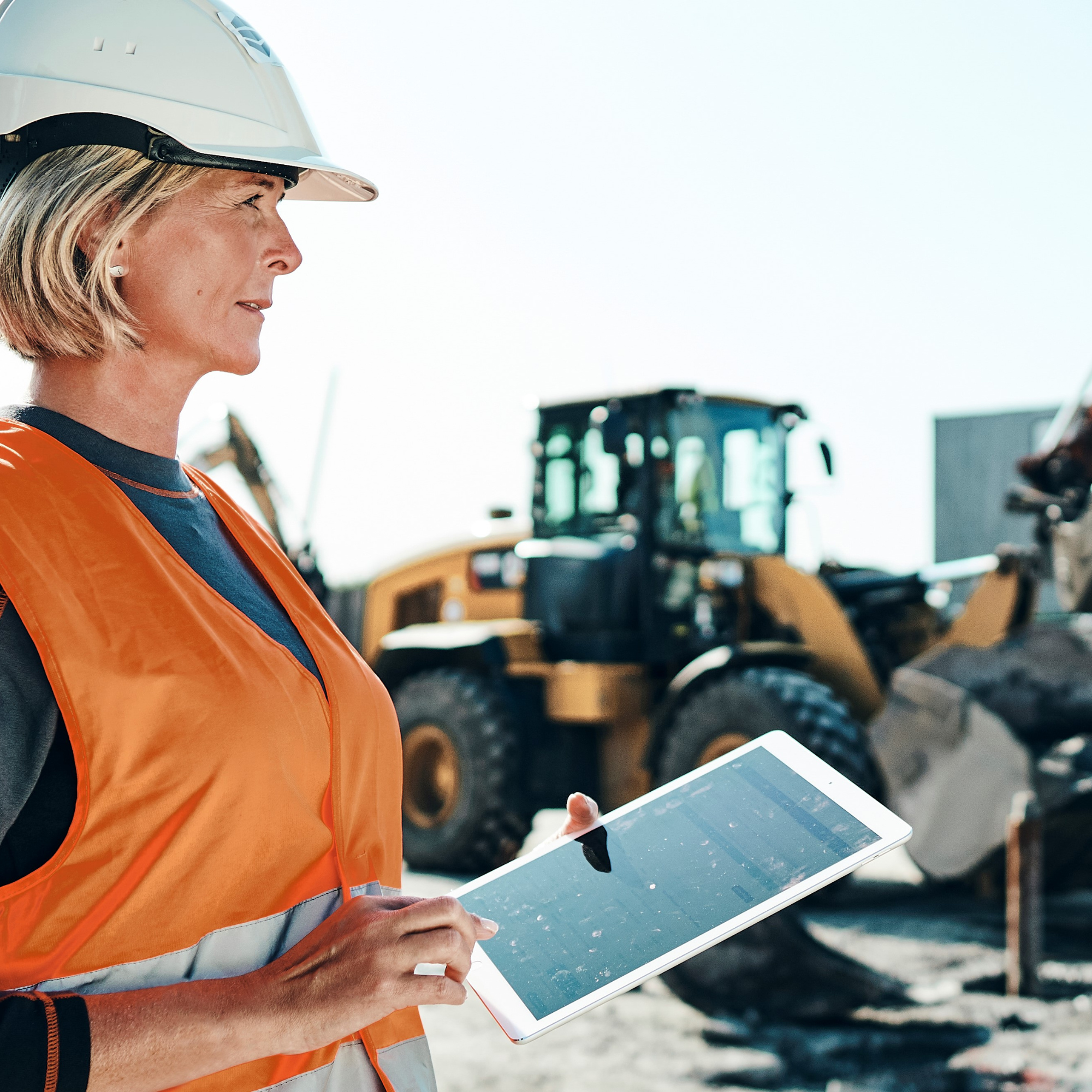 Construction worker managing vehicles on ipad