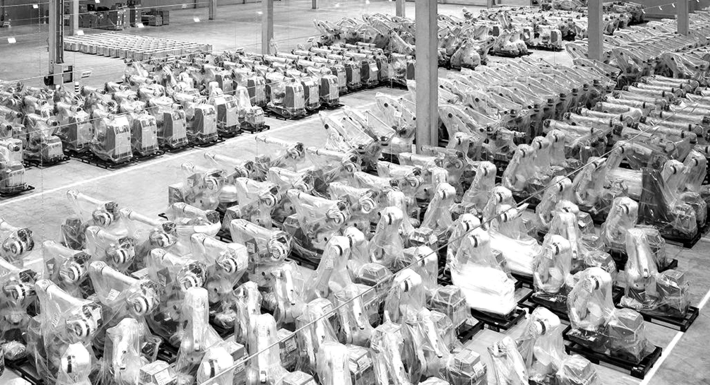 Black and white picture showing warehouse with lines of machinery