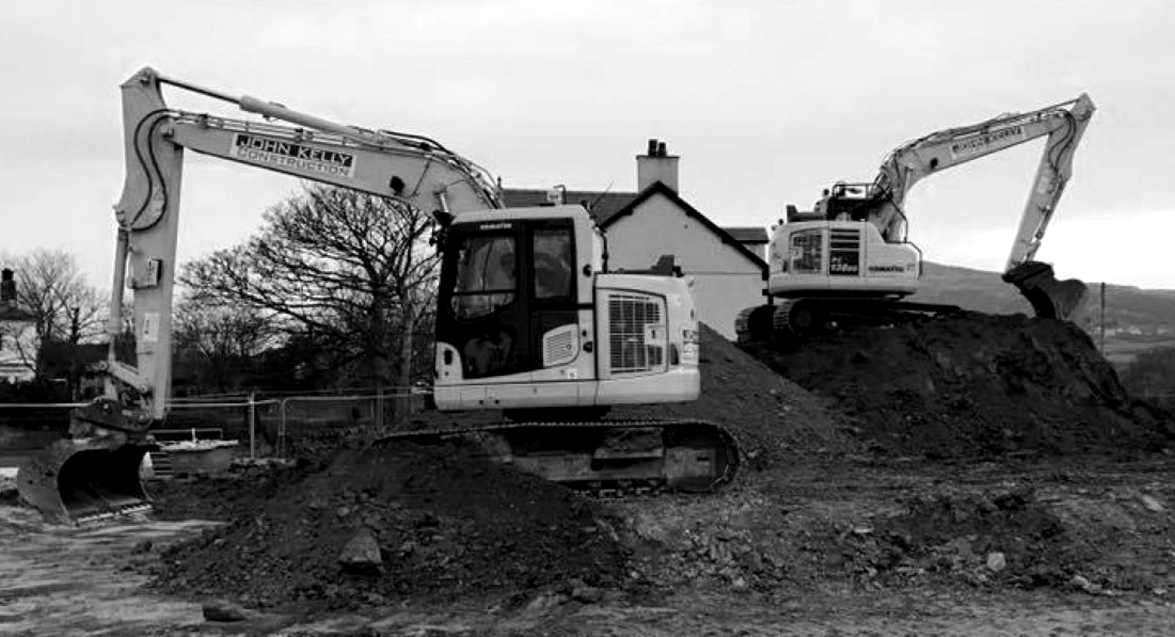 Black and white image showing diggers working on site