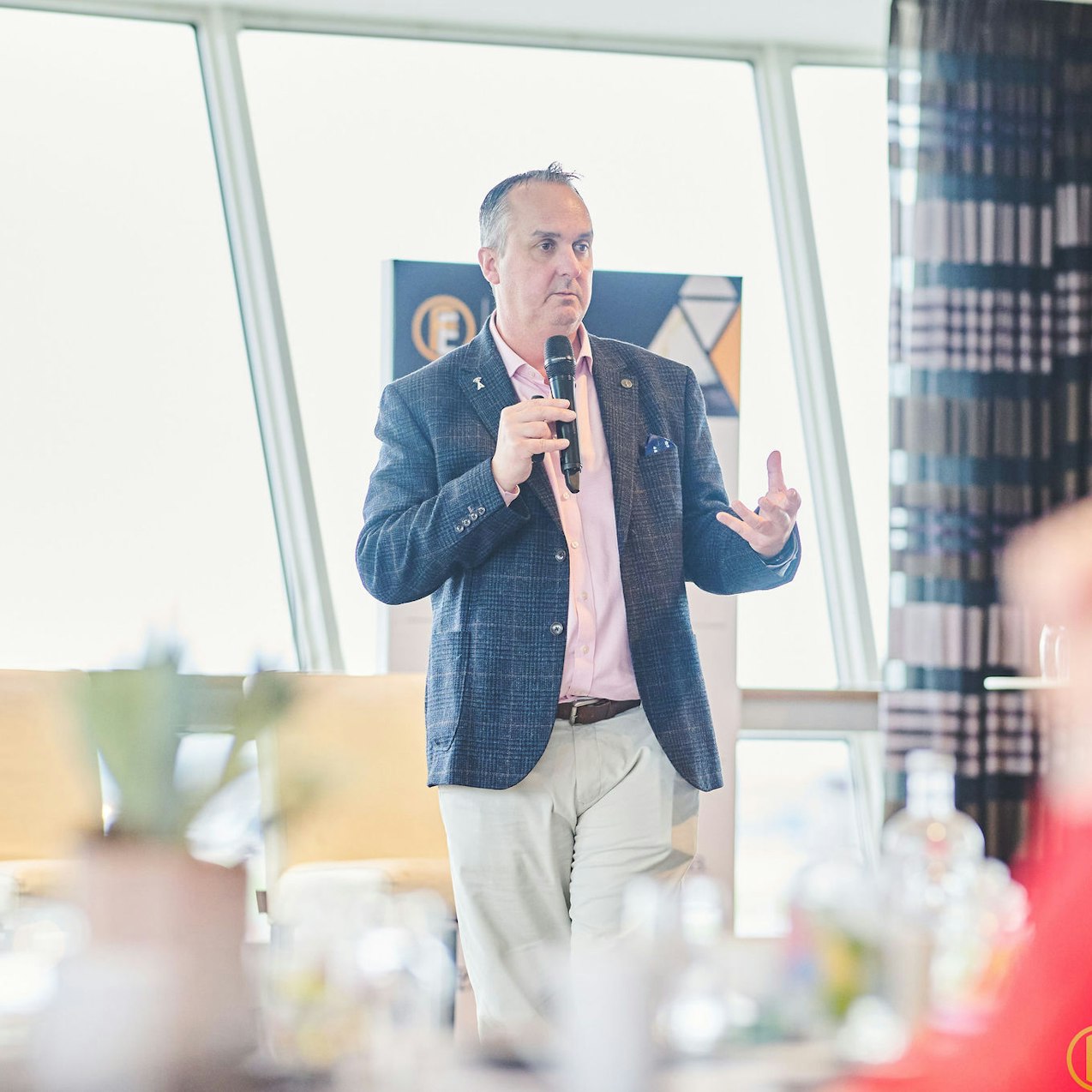 Craig Allan from ABAX presenting to crowd, holding a microphone