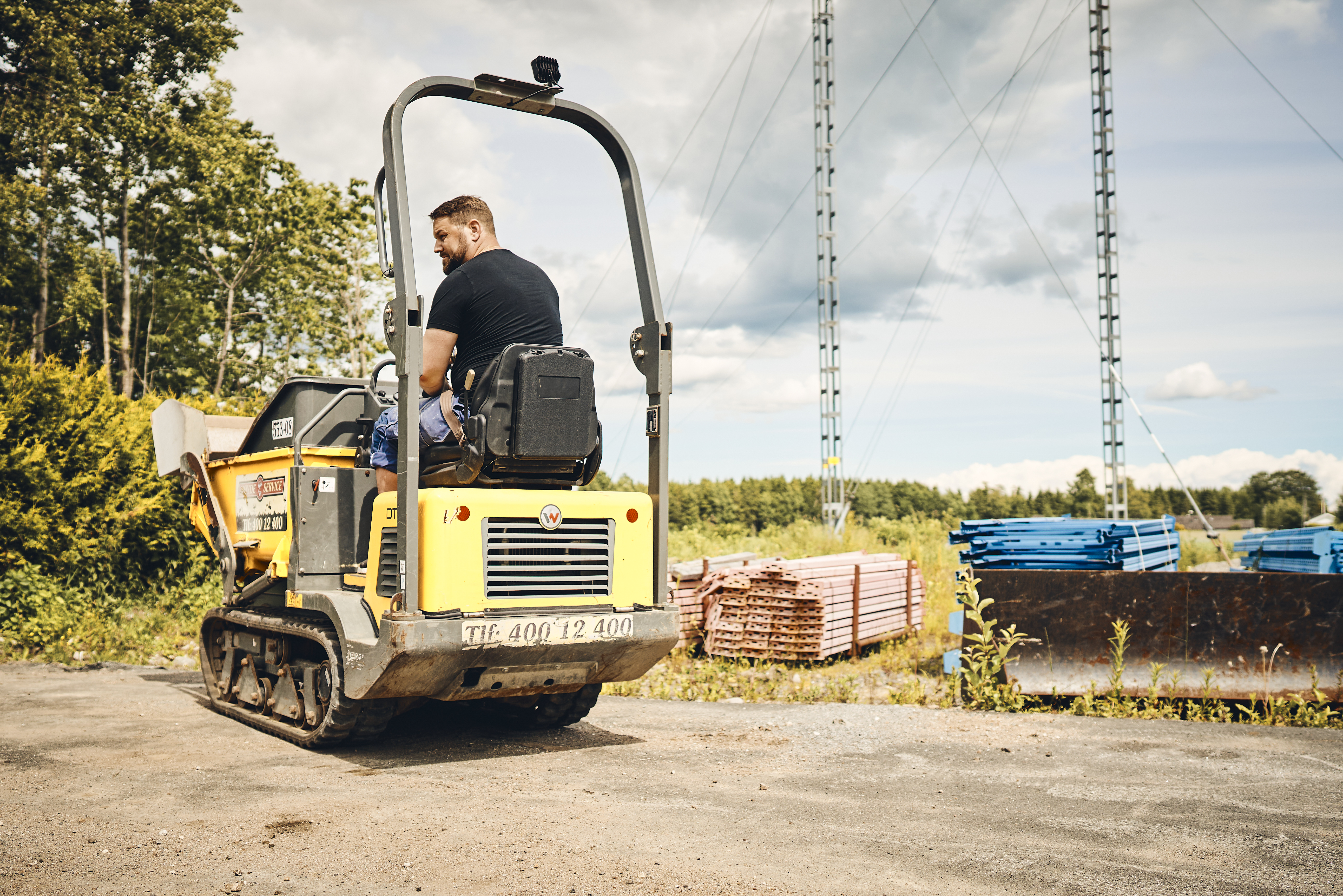 Man sitting on yellow plant machinery on road