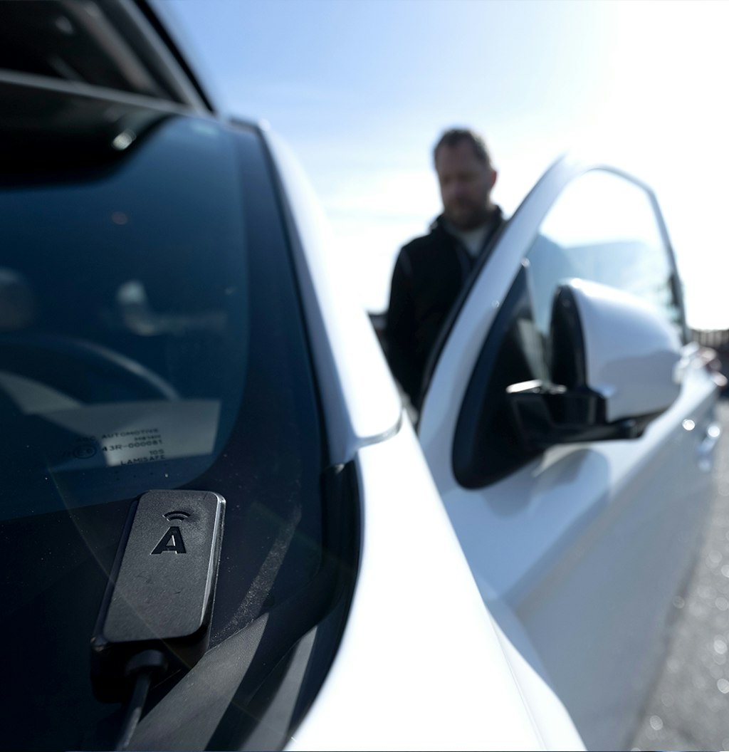 En arbetare hoppar in i en bild där en körjournal finns installerad på vindsrutan