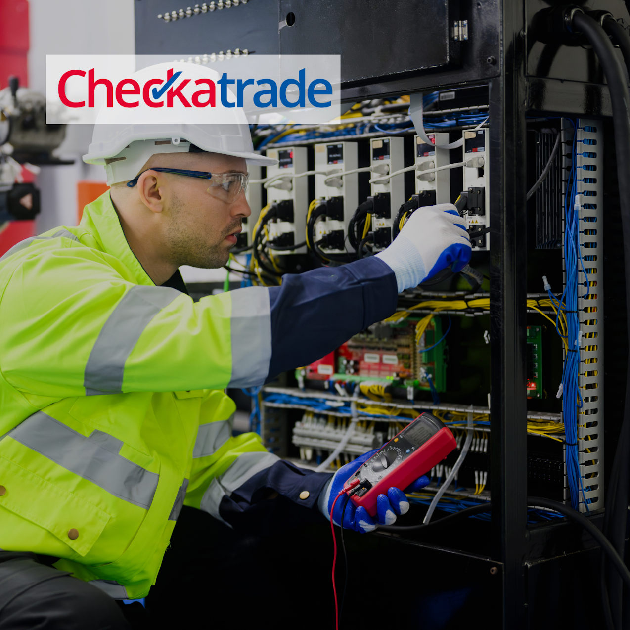 Electrician in hi-vis and safety clothes checking a switchboard