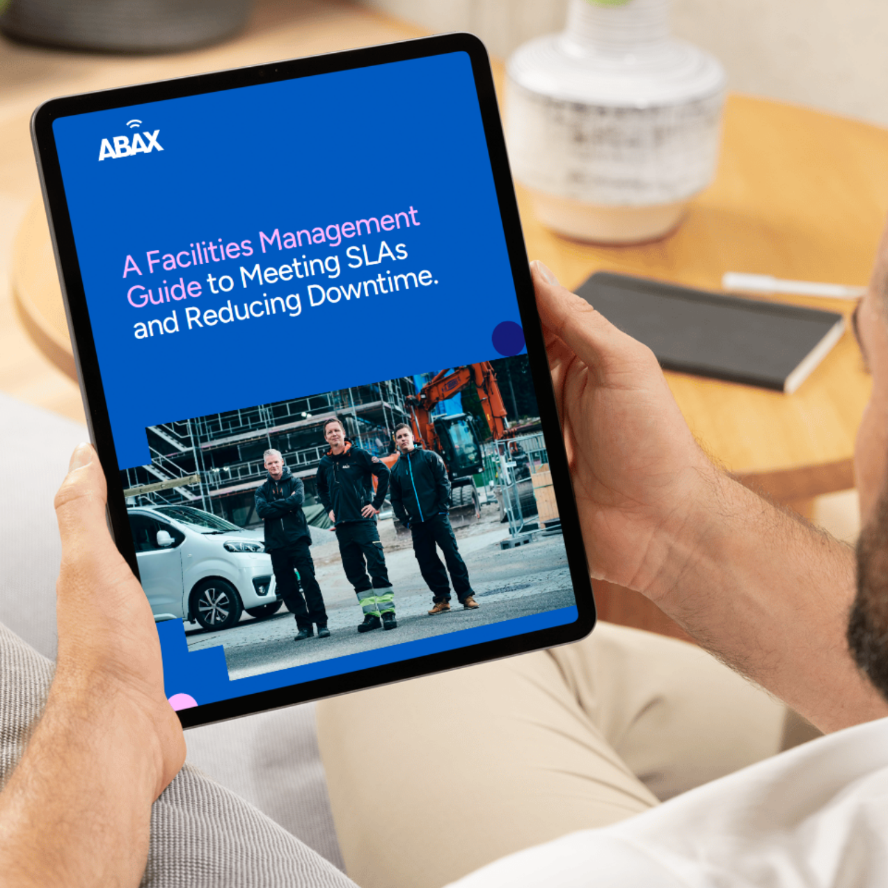 Facilities Management Guide on iPad, man sat on sofa
