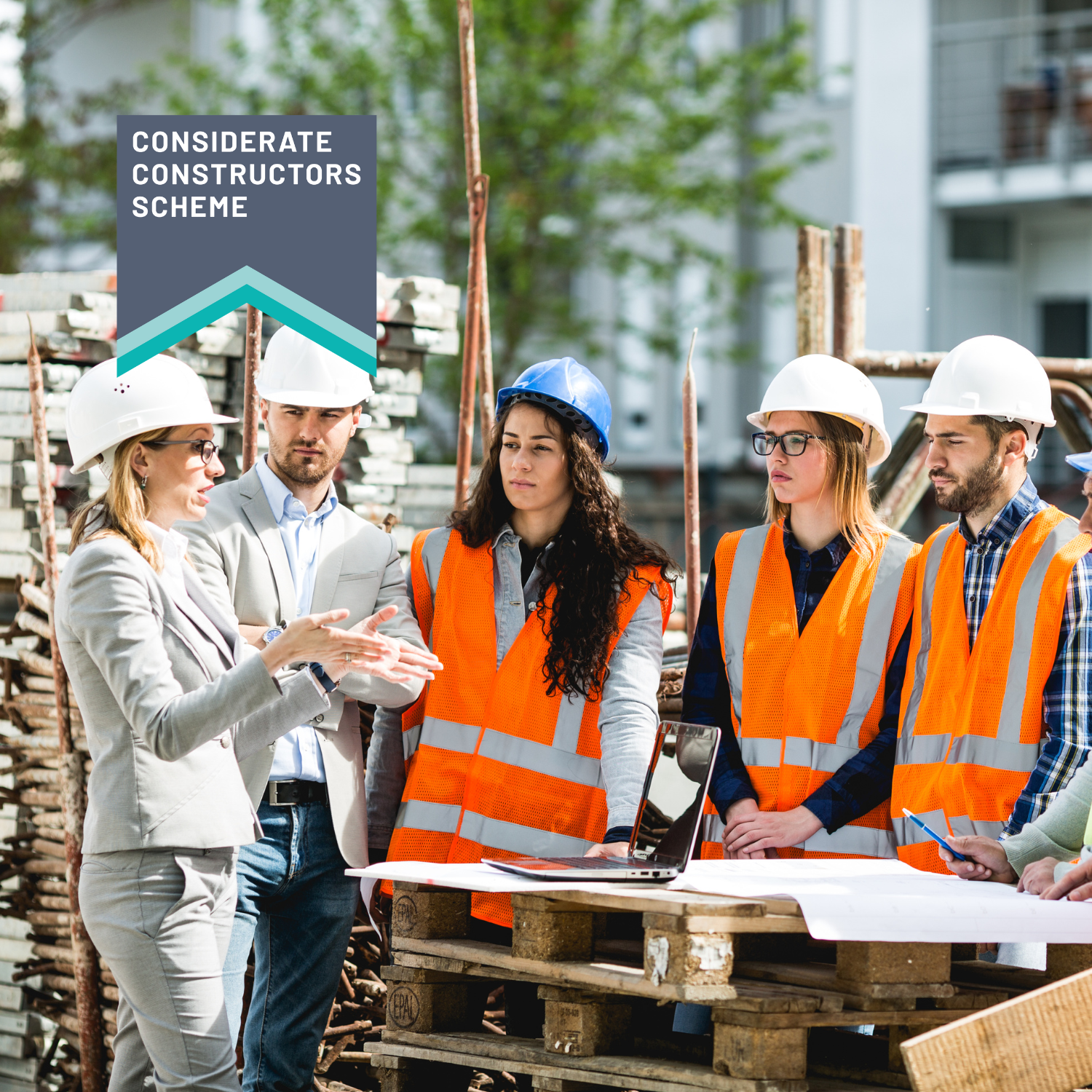 Construction workers in hard hats and high vis having a meeting outside