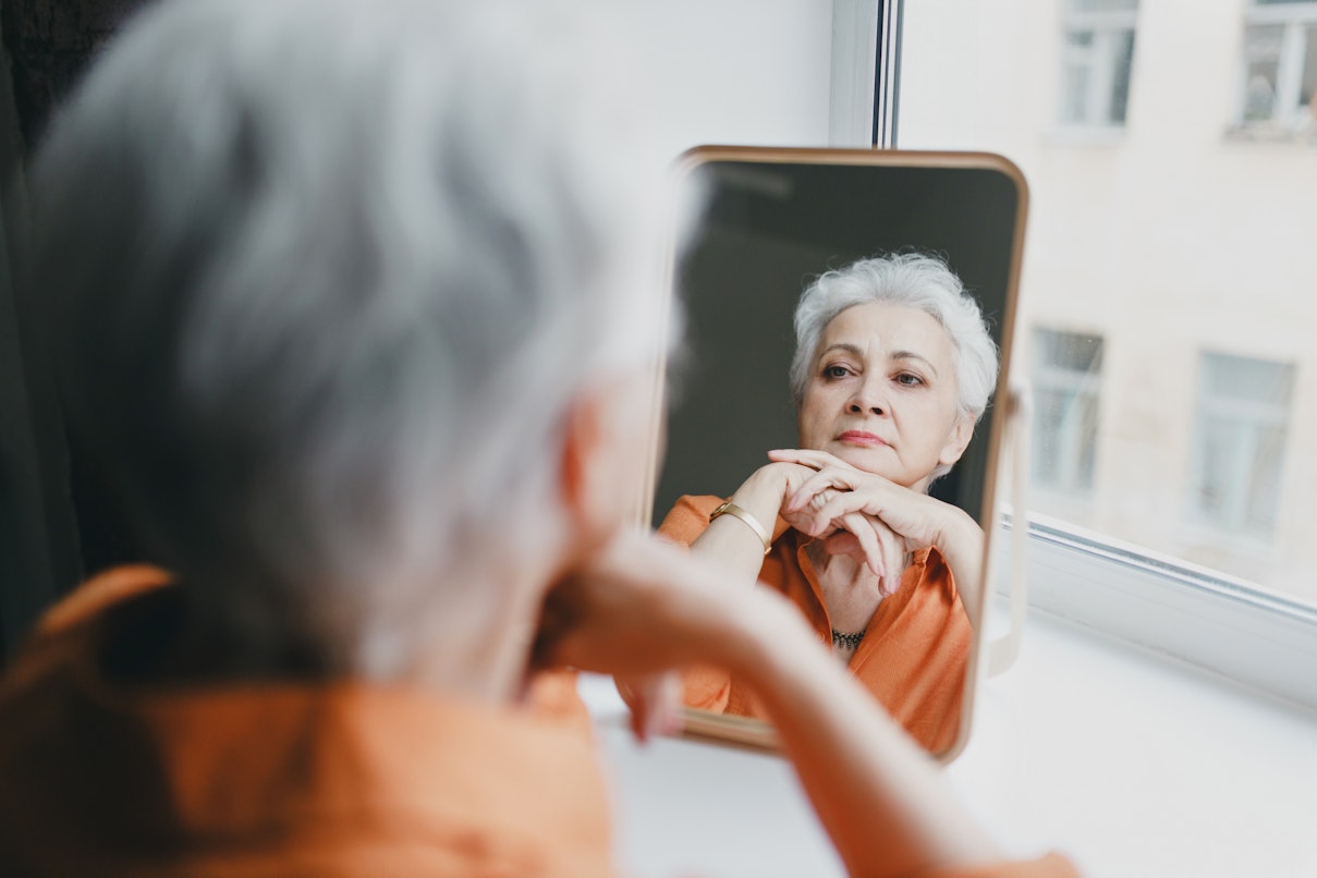 Older woman staring into a mirror