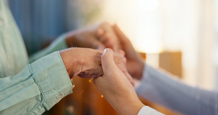 Young carer holding hands with older woman