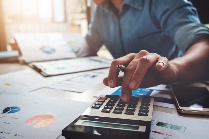 Person using a calculator and looking at documents