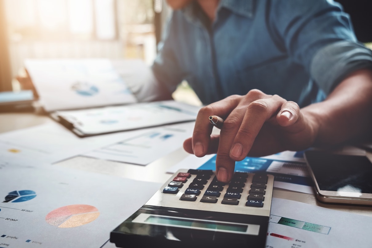 Person using a calculator and looking at documents