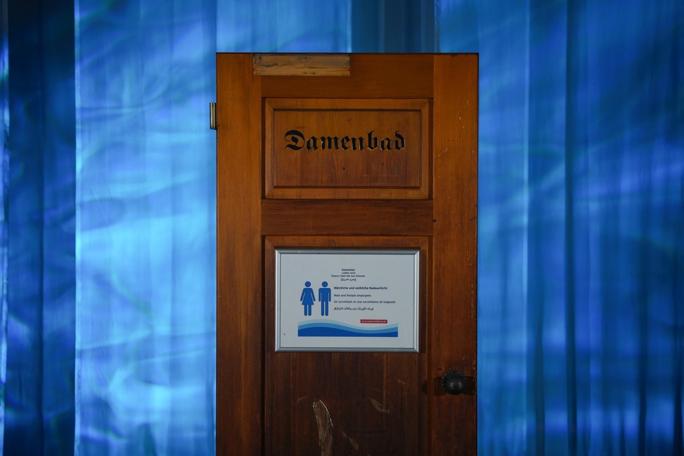 Bild aus der Sonderausstellung „Frei Schwimmen“ im Haus der Geschichte Baden-Württemberg, u. a. mit Objekten wie der Tür des „Loretto“-Bads in Freiburg, an der sich (Frauen-)Geschichte ablesen lässt; zu sehen bis 12. April 2026; © Haus der Geschichte Baden-Württemberg