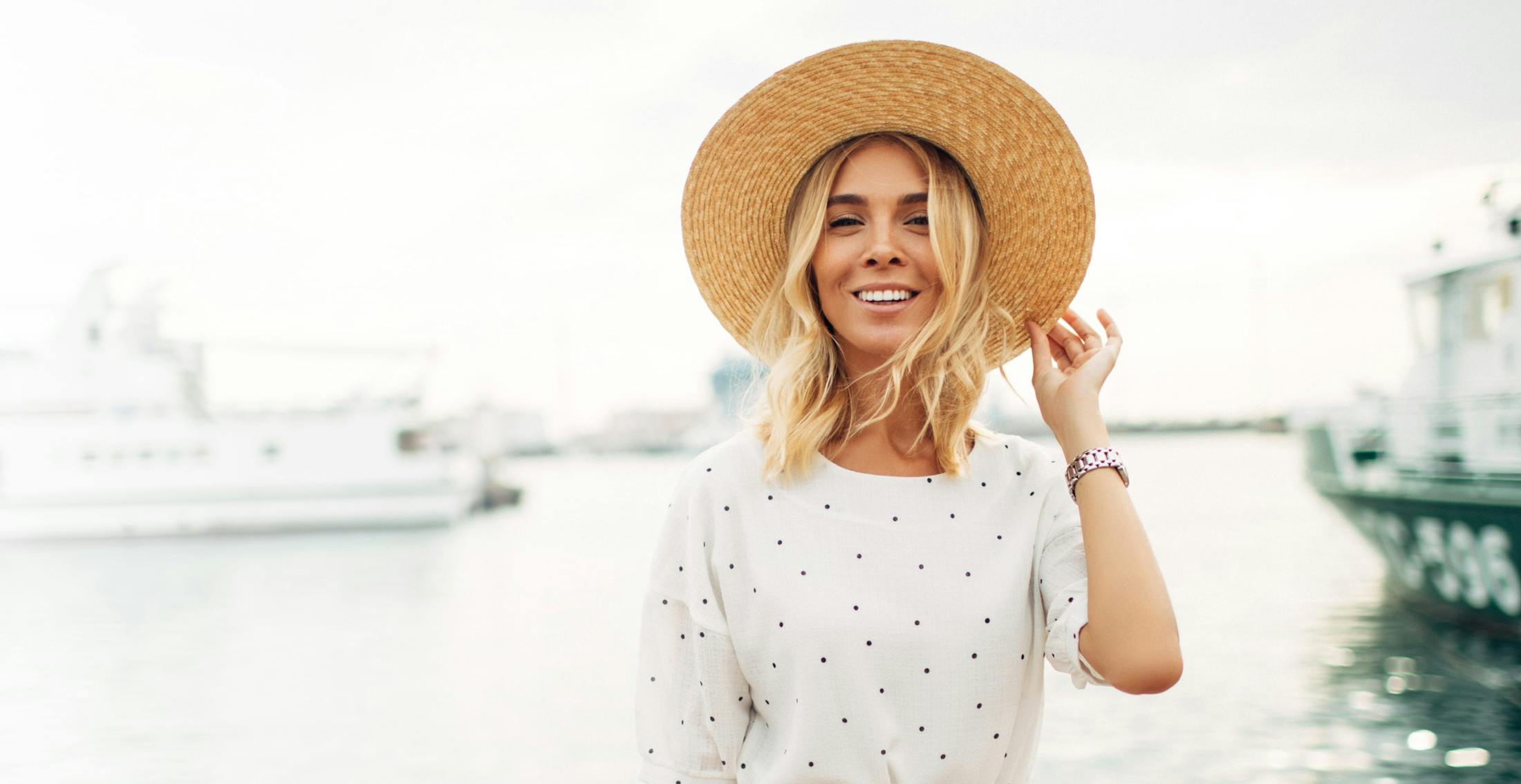 Woman wearing a white dress and straw hat outside