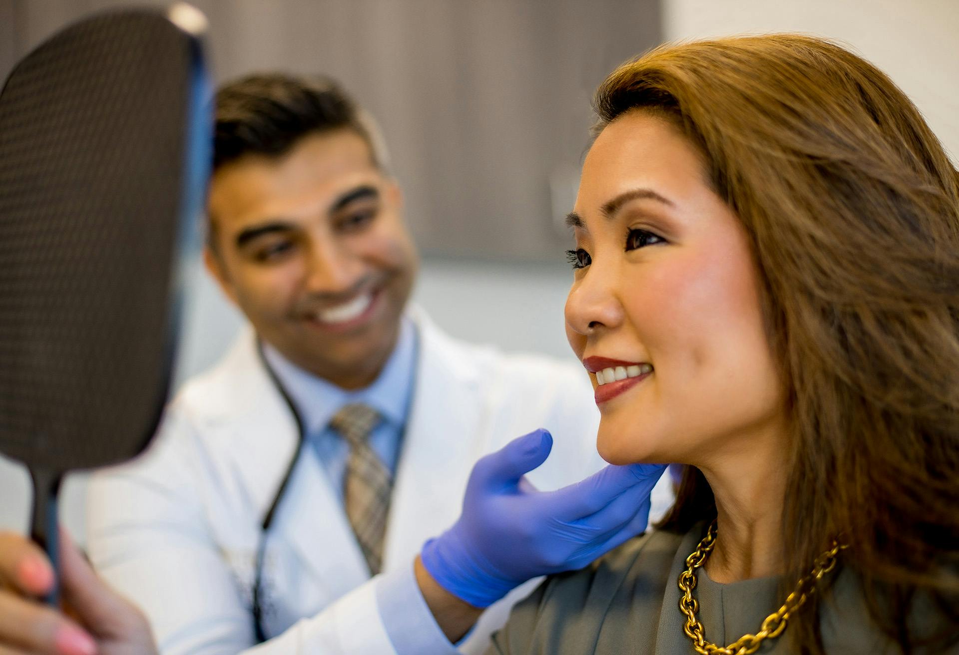 Woman Looking at her Facelift Results in the Mirror