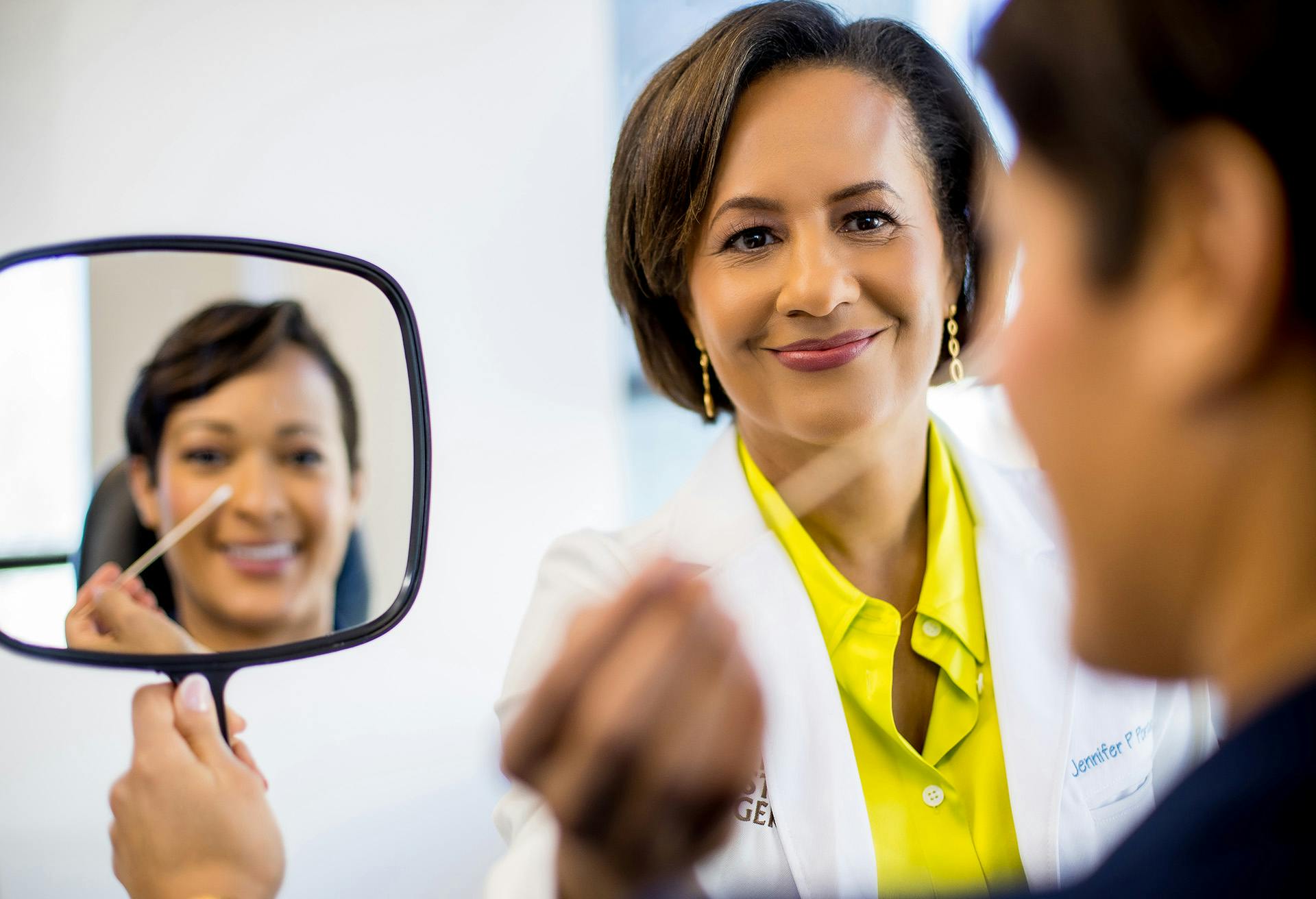Patient looking at their Facial Plastic Surgery Results in the Mirror