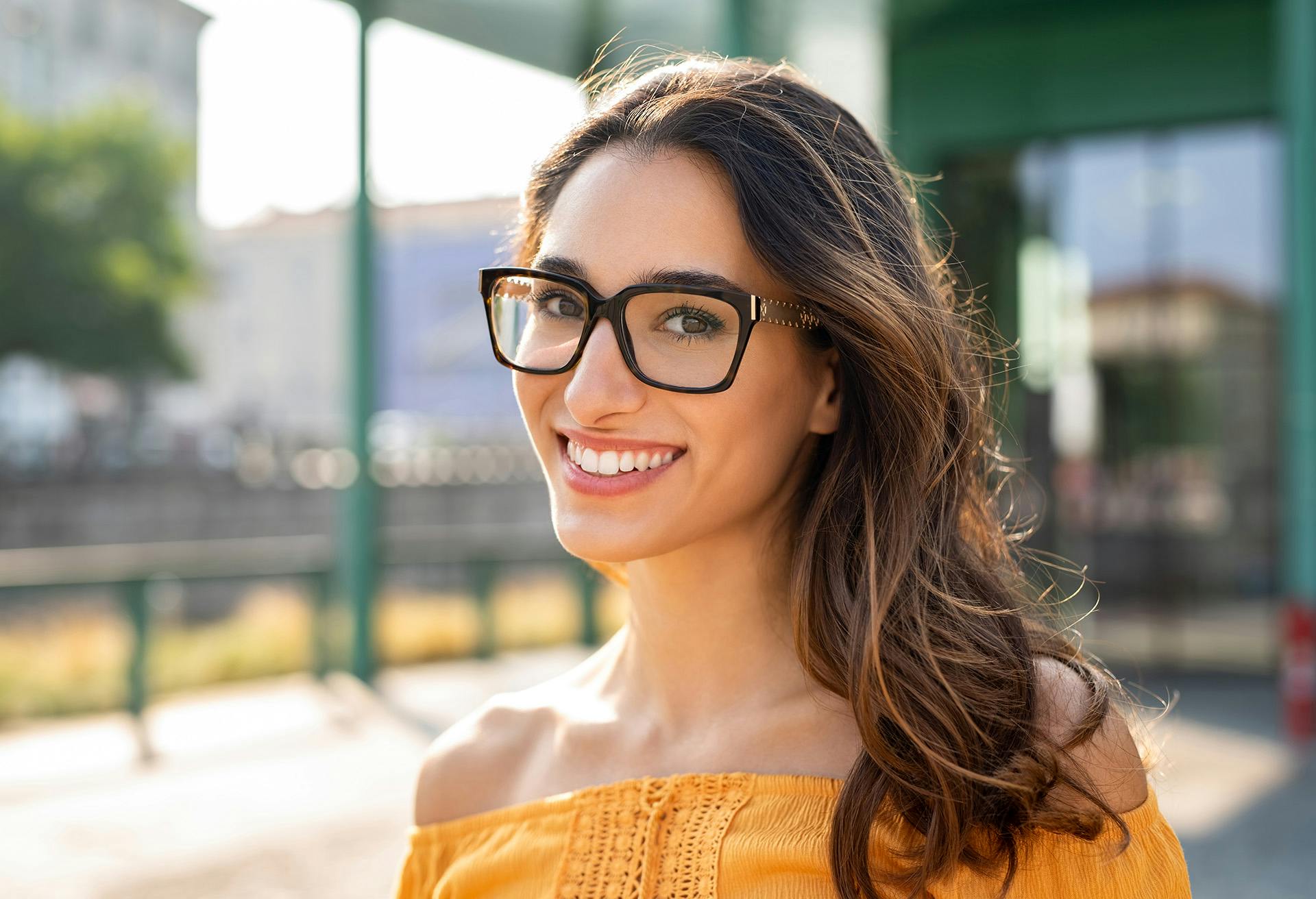 Woman with long curly brown hair wearing glasses