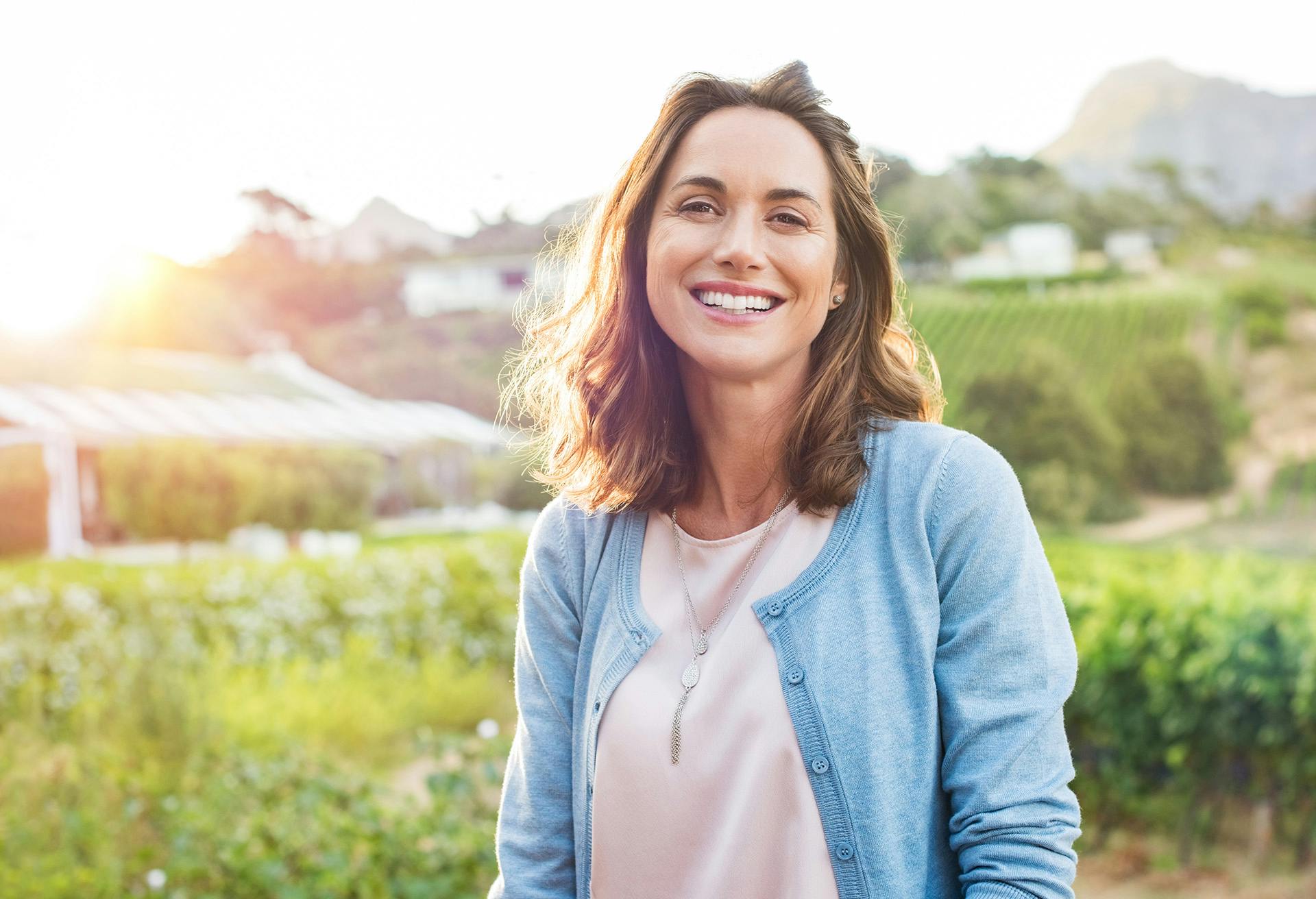 Woman with Blue Sweater and Farmland in the Background