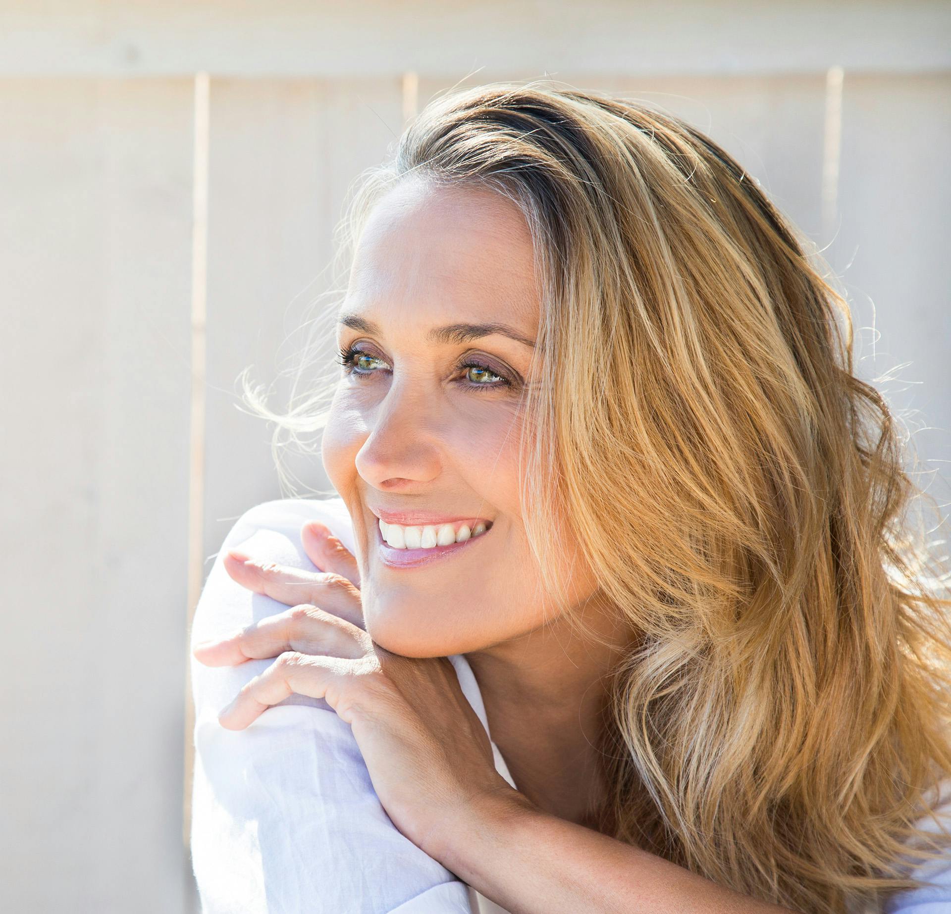 Smiling Woman with Blonde Hair Looking Over Her Shoulder