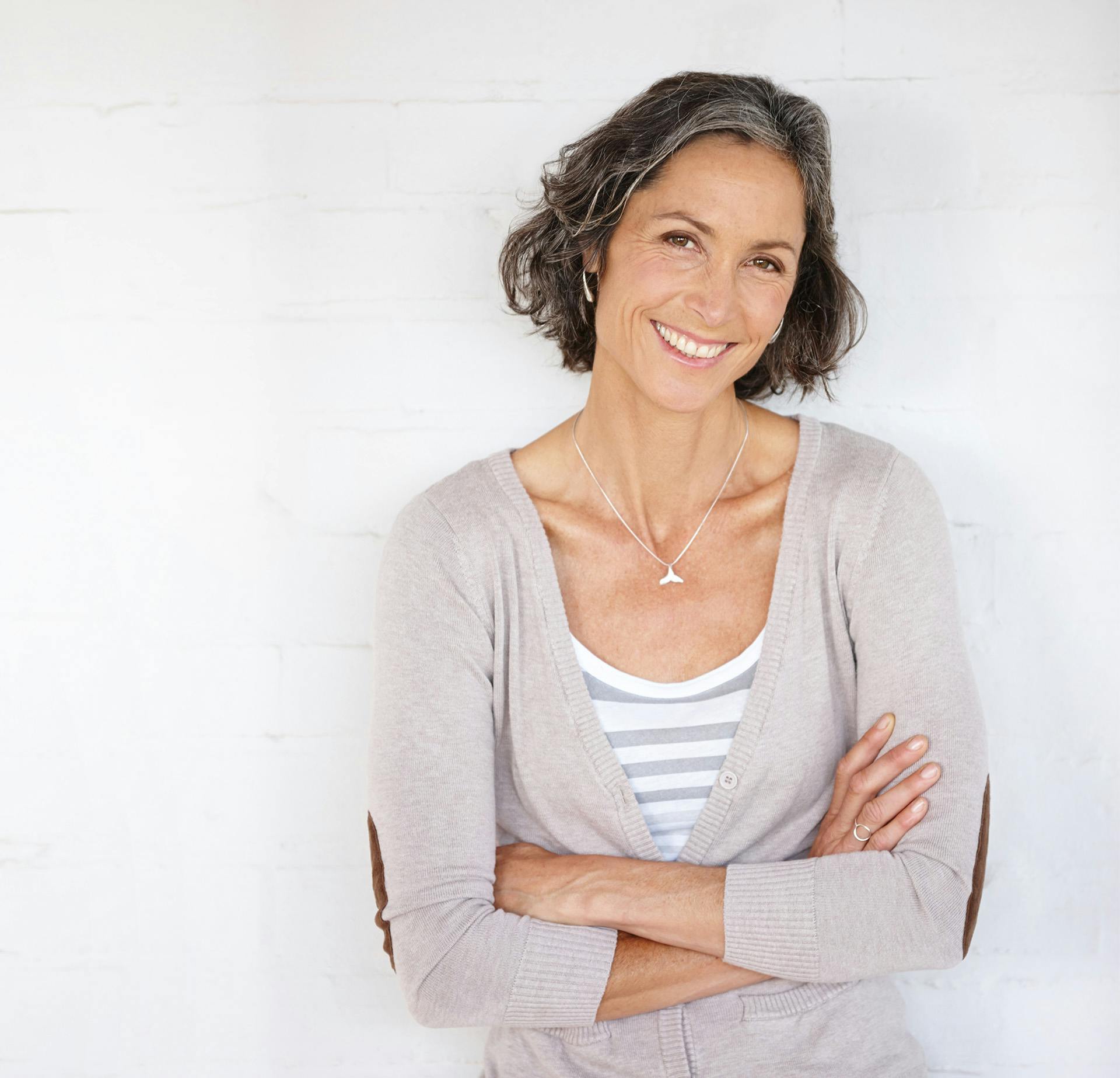 Beautiful middle aged woman with salt and pepper hair, smiling
