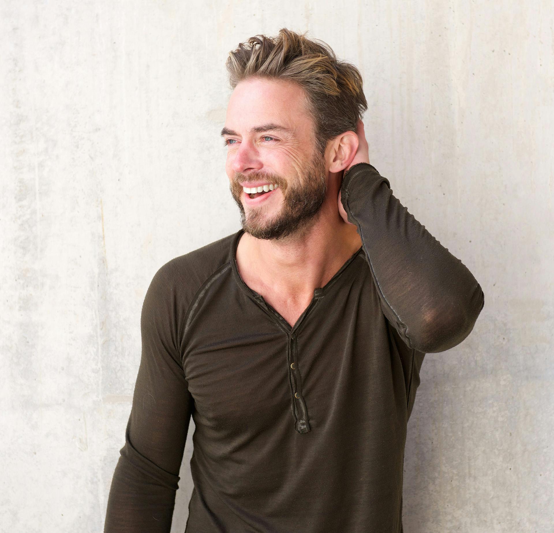Man smiling while wearing a long sleeve black shirt