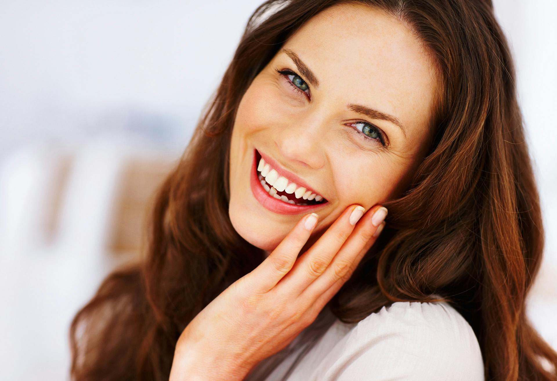 Woman Smiling with her Hand on her Cheek