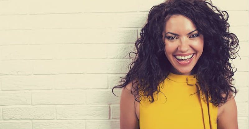 Smiling Woman with Long Dark Hair and Yellow Shirt