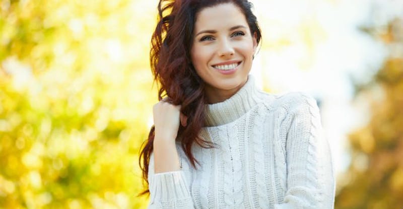 Woman with Wavy Dark Hair and Trees in the Background