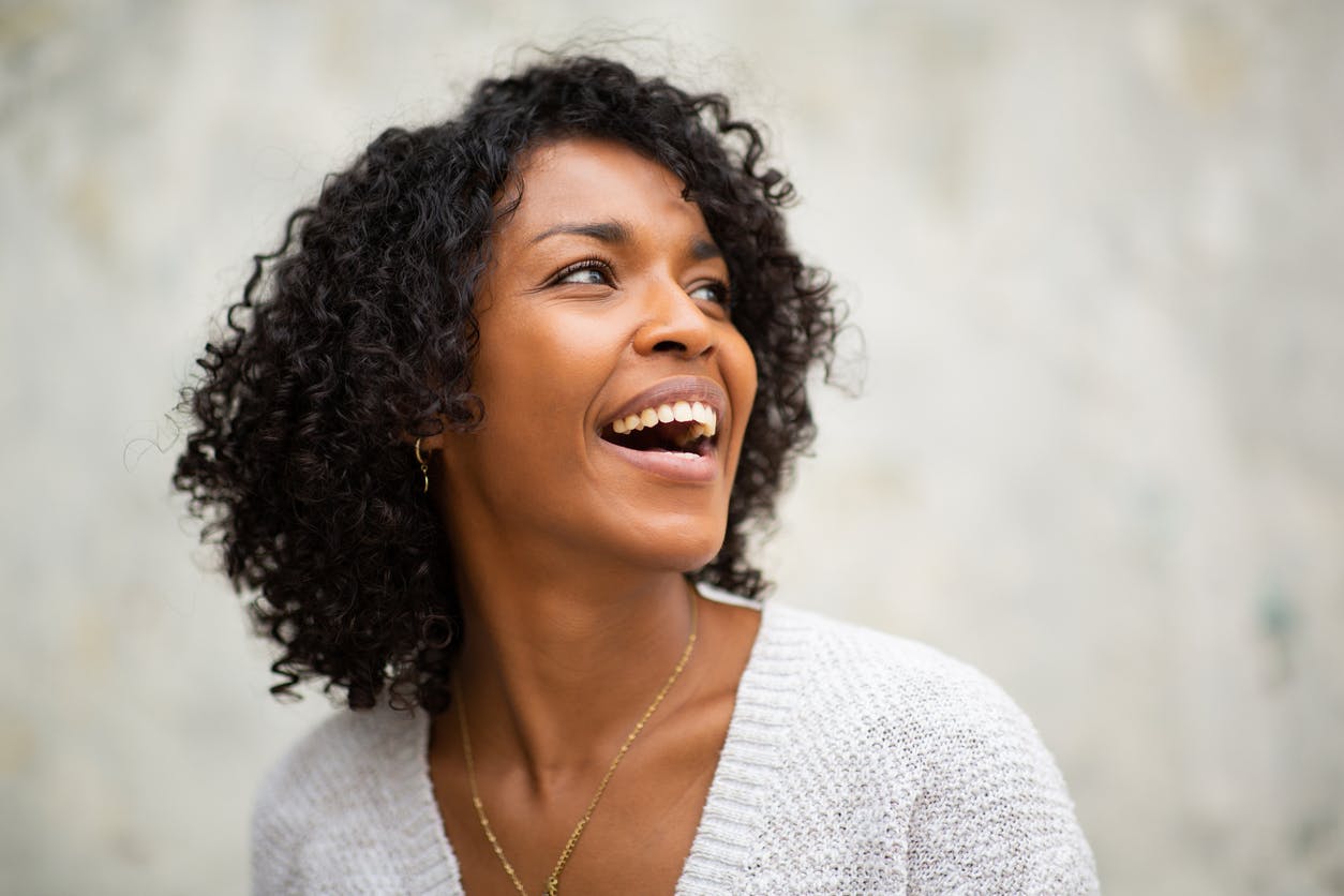 Woman smiling naturally with a bright, expressive facial appearance