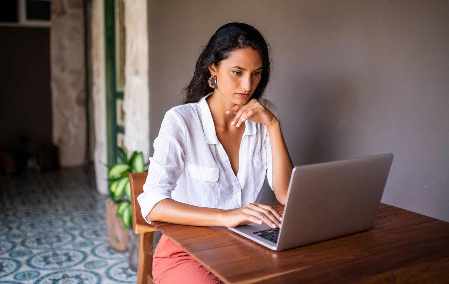 woman sitting at a table with a laptop