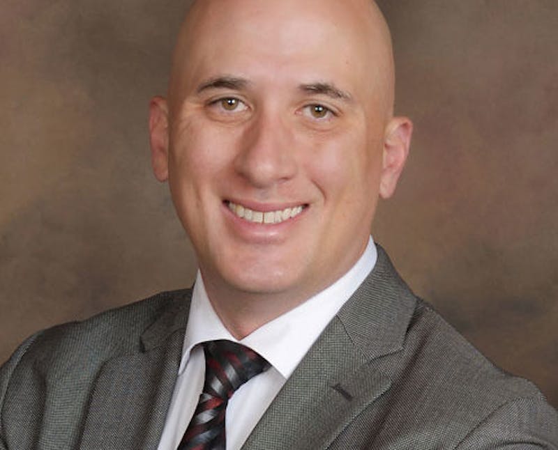 man in a suit and tie smiling for a picture
