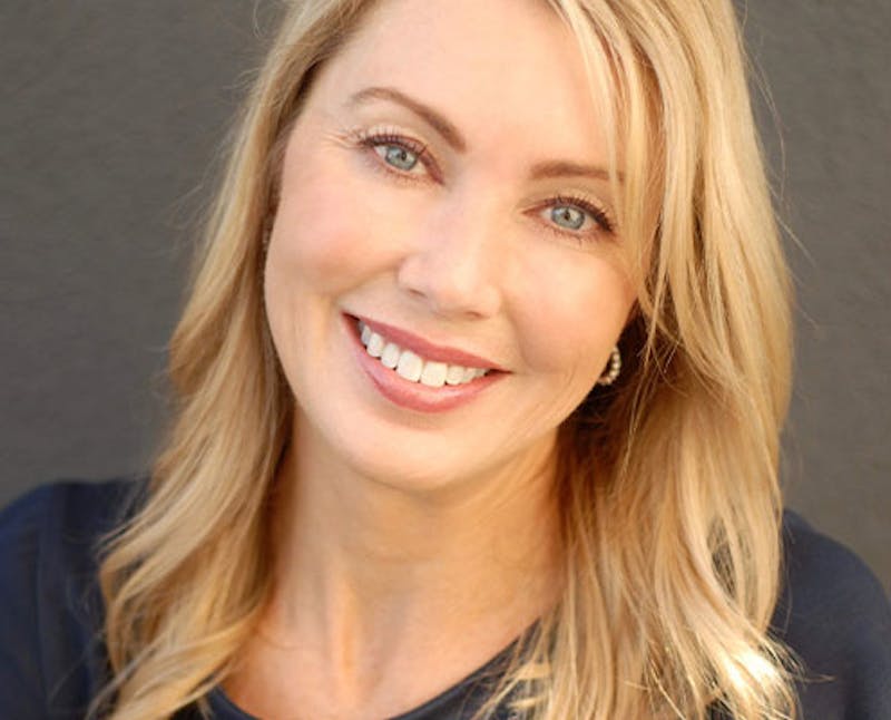 blond woman with blue eyes and a black shirt smiling