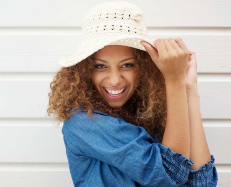 smiling woman in a white hat and blue shirt