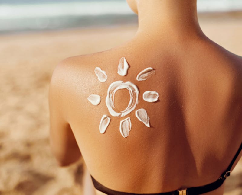 Woman with sunscreen on her back in the shape of a sun