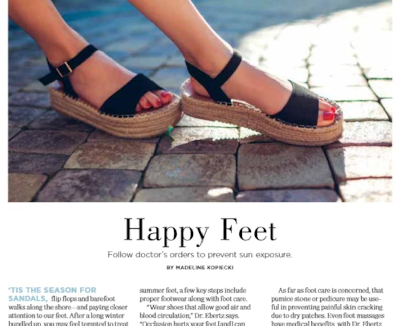 a close up of a person wearing sandals on a brick floor