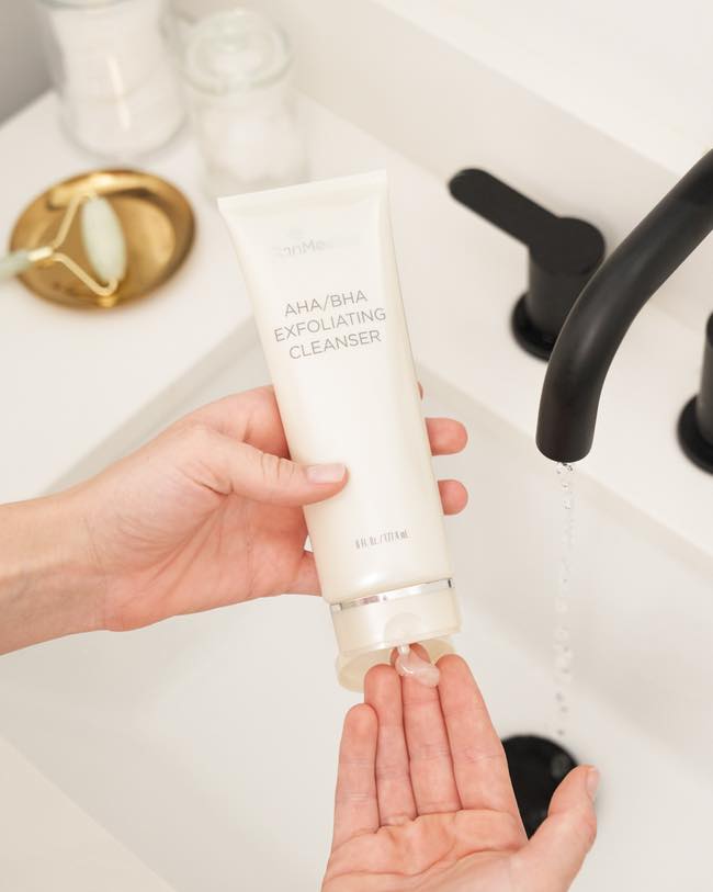 AHA/BHA exfoliating cleanser being put in hand over sink