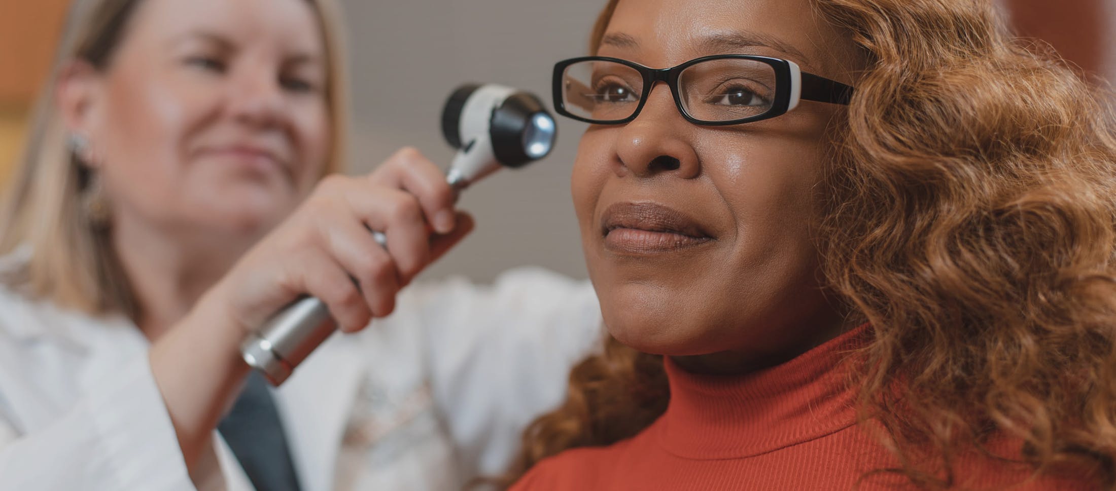 Doctor looking into a female patients ear