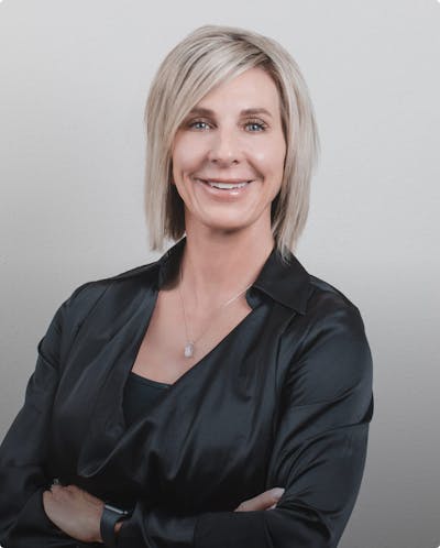 blond woman in black shirt looking at camera