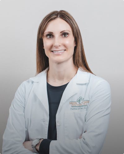 Physician Nadine Miller in a lab coat smiling for a picture