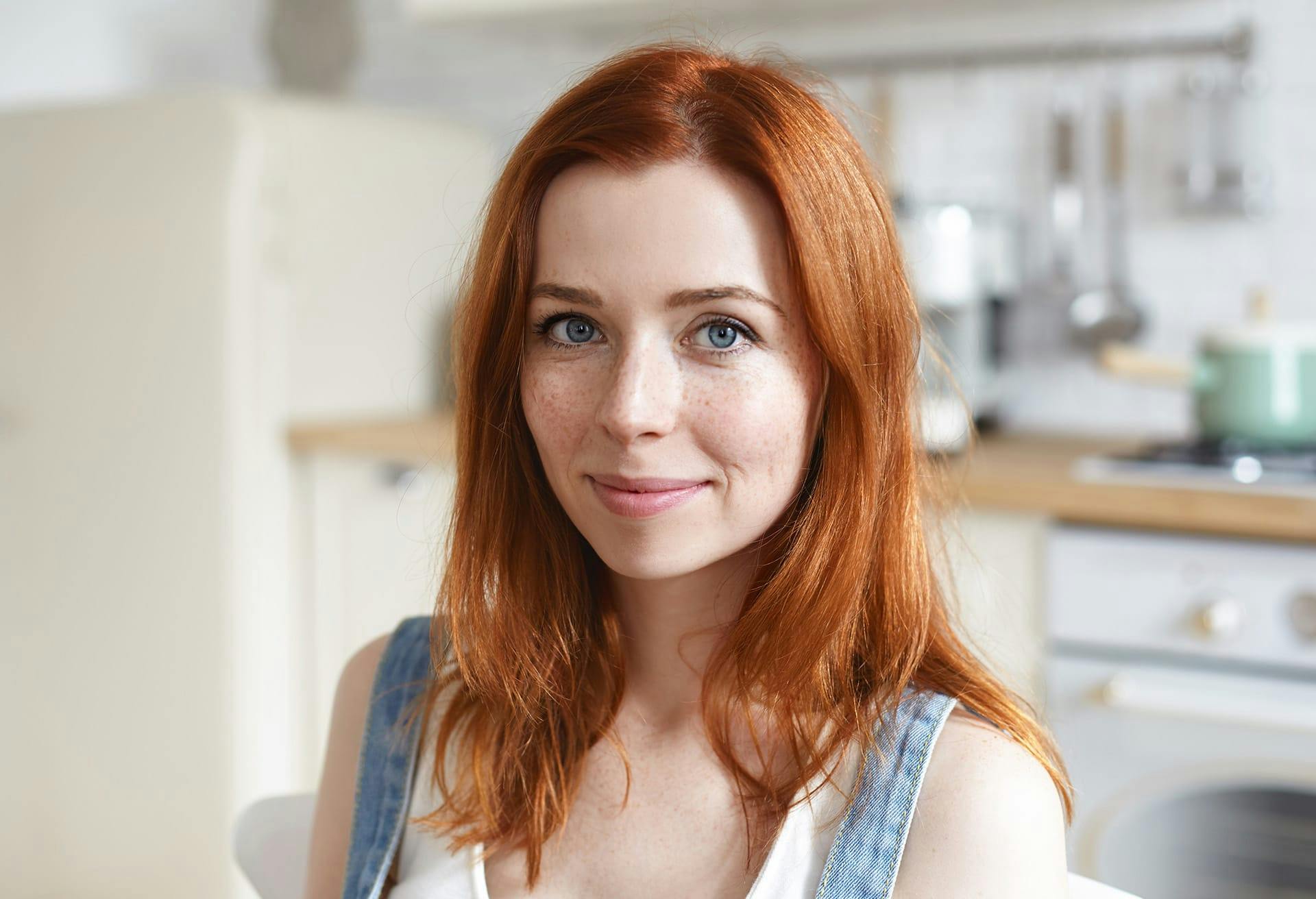 woman with red hair sitting in a kitchen