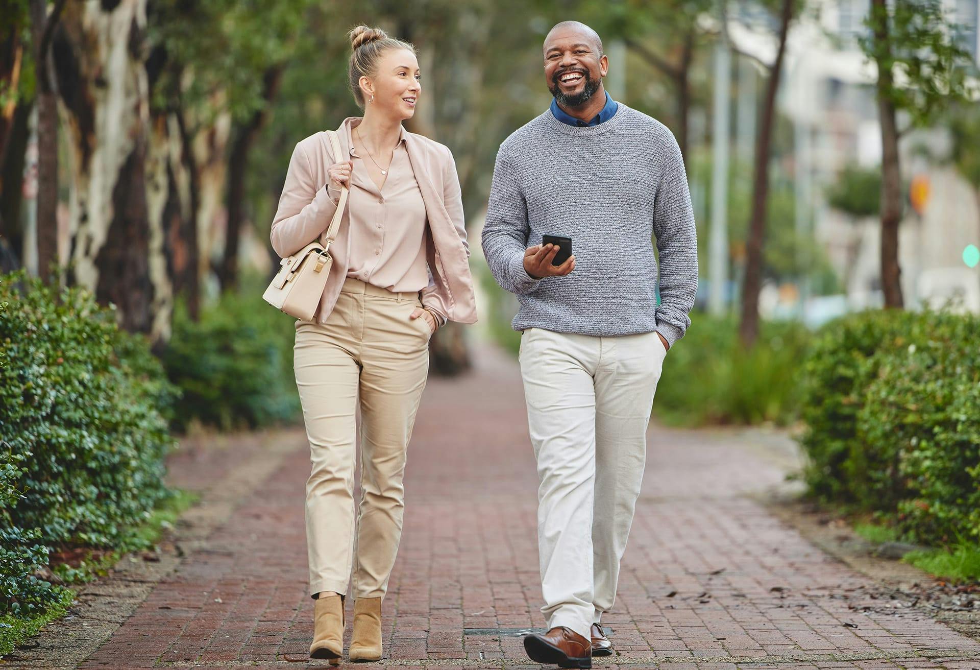 Man and woman dressed nicely walking on the sidewalk