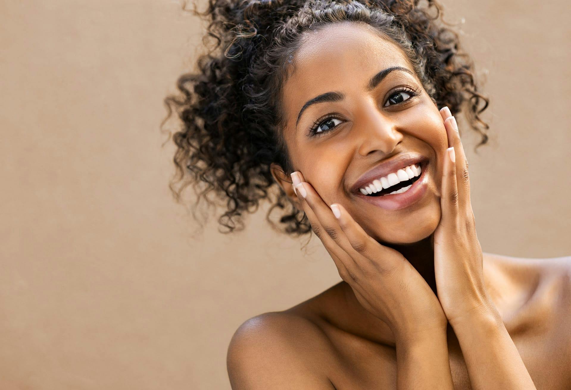 Woman smiling and touching her cheeks