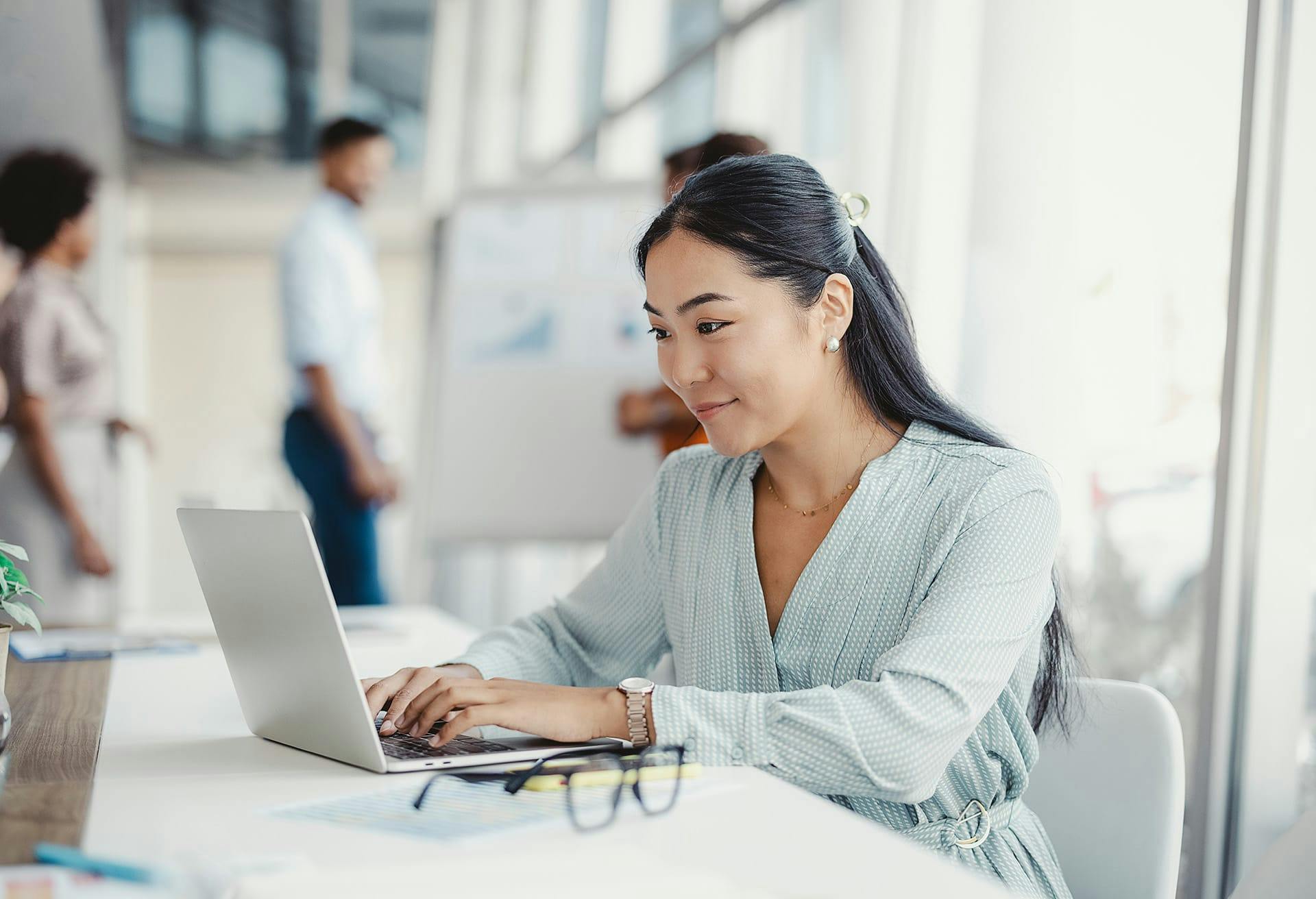 woman sitting at a table with a laptop in front of her