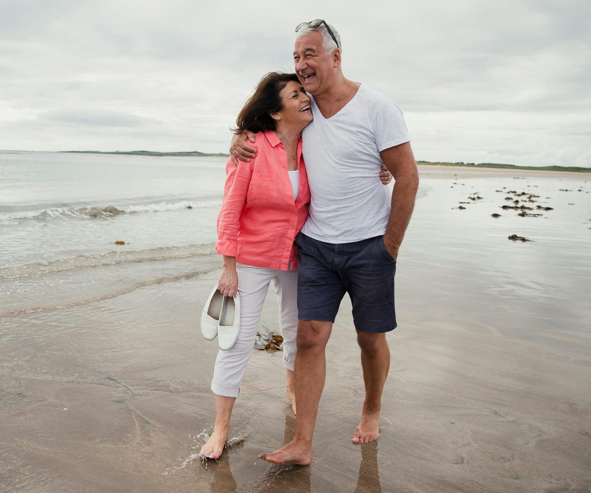 there is a man and woman standing on the beach together