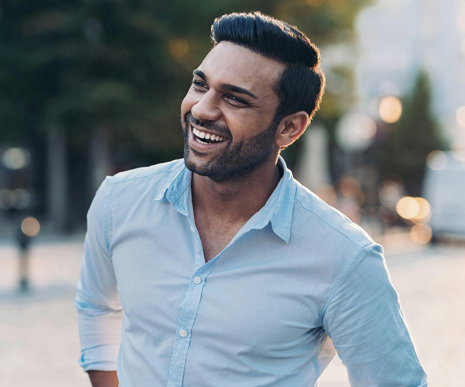 Man in a blue button up top smiling