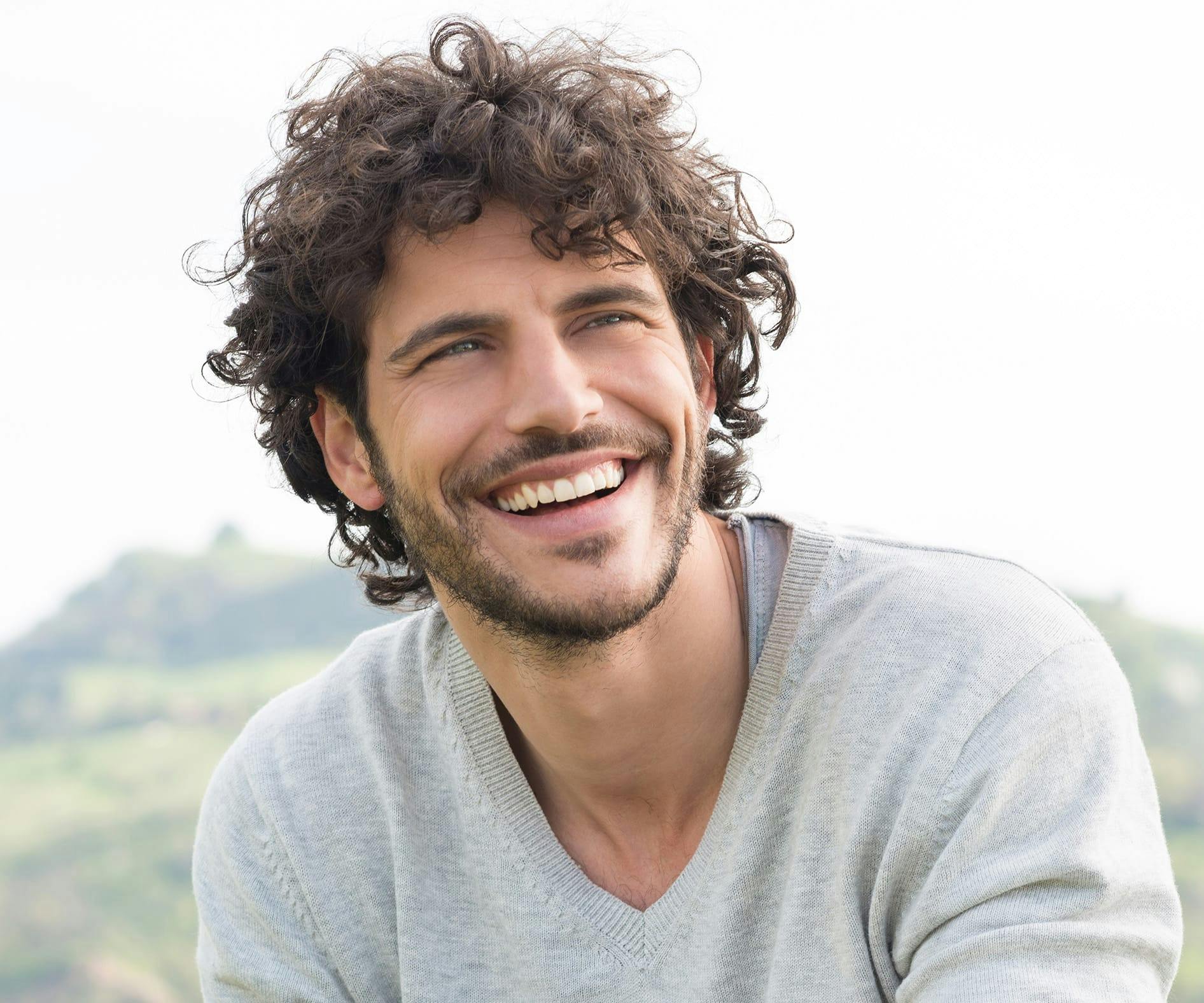 Man with curly hair smiling